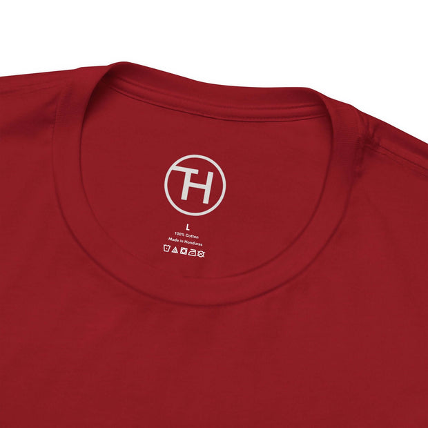 Close-up of the neckline of a red unisex dog lover tee with tag showing 100% cotton material.