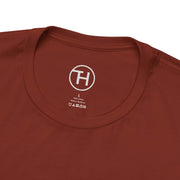 Close-up of a rust-colored unisex tee collar, showcasing soft fabric and brand logo.