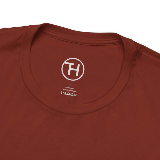 Close-up of a rust-colored unisex tee collar, showcasing soft fabric and brand logo.