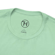 Close-up of the collar and label of a mint green Kid & Puppy Love T-Shirt made from 100% lightweight cotton.